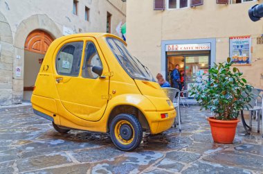FLORENCE, ITALY - 25 Eylül 2019 Şehir merkezinin dar sokağında elektrikli araba Pasqali park etti.