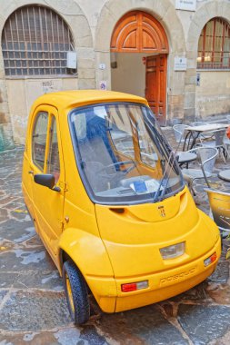 FLORENCE, ITALY - 25 Eylül 2019 Şehir merkezinin dar sokağında elektrikli araba Pasqali park etti.