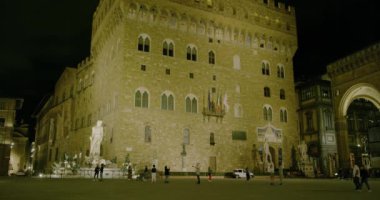 FLORENCE, ITALY - 25 Eylül 2019 Geceleri, Piazza della Signoria 'daki Neptün Pınarı' nın önünden geçen insanlar.