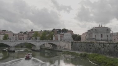 ROME, ITALY - 26 Eylül 2019 Bir turist gemisi bulutlu bir günde Ponte Vittorio Emanuele II köprüsünün altından geçiyor.