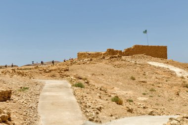 MASADA, ISRAEL - 21 Mayıs 2016: Güney İsrail çöllerindeki antik kalenin Masada kalıntılarını ziyaret eden turistler.