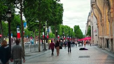 Paris, Fransa - 9 Temmuz 2015: Champs Elysees caddesinde dilencilik yaparken yayalar geçerken.