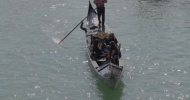 Venedik, İtalya - 11 Nisan 2023: Gondol, Rialto Köprüsü 'nden Büyük Kanal manzarasını geçiyor. Yavaş çekim..