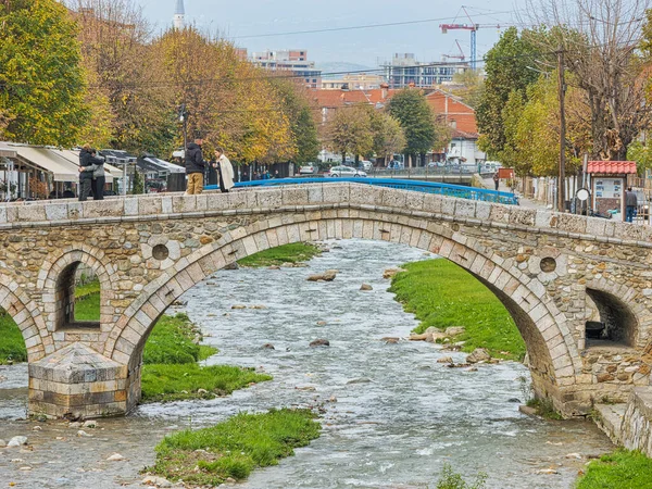 Prizren Kosovo 2022年11月13日 市内中心部のビストリツァ川沿いの古い石造りの橋を歩く人々 — ストック写真