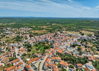 Bale, Hırvatistan - 27 Haziran 2023: Güneşli bir günde eski kentin havadan görünüşü Kutsal Bakire Meryem 'i Ziyaret Kilisesi' nin kalbinde eşmerkezli daireler çizerek yayılıyor.