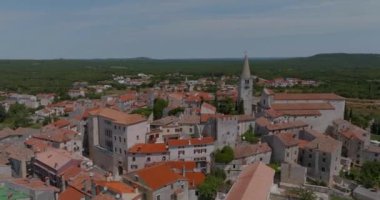 Bale, Hırvatistan - 27 Haziran 2023: Güneşli bir günde eski kentin havadan görünüşü Kutsal Bakire Meryem 'i Ziyaret Kilisesi' nin kalbinde eşmerkezli daireler çizerek yayılıyor.