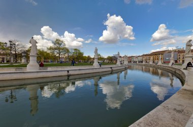 PADUA, İtalya - Nisan 03 2023: Prato della Valle Meydanı 'nda bahar mevsimi, canlı kaynak yansımaları ve hareketli kalabalıkla.
