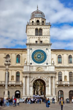 PADUA, ITALY - 04 Nisan 2023: Sabah Piazza dei Signori 'nin yürüyüşü, tarihi Saat Kulesi' nin altını çiziyor. Dönüşümlü lens görüntüsü