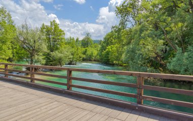 Overlooking the tranquil flow of the Una River from a bridge, offering a captivating view of its course through the heart of Bihac.