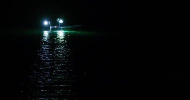 Bir balıkçı teknesi, Adriyatik Denizi 'nin sakin sularına yansıyan güzel yansımaları yakalamak için geceleyin parladı.