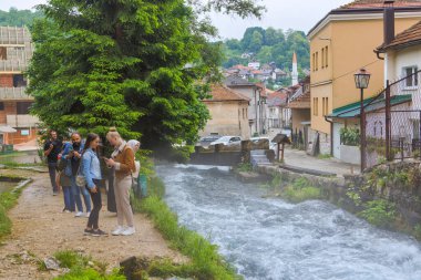 TRAVNIK, BOSNIA AND HERZEGOVINA - June 3, 2023: Panoramic view of visitors exploring the iconic Blue Water, Plava Voda, Spring. clipart