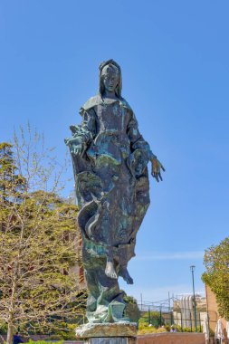 Venedik, İtalya - 10 Nisan 2023 Venedik tren istasyonunda açık mavi gökyüzüne karşı Bakire Meryem bronz heykeli.