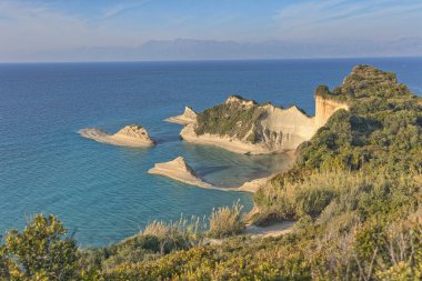 Korfu 'daki Cape Drastis sahil kayalarının panoramik görüntüsü, gün batımından hemen önce yumuşak ışıkta yıkandı..