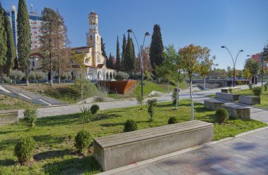 FIER, ALBANIA - 20 Ekim 2022: Şehir parkının manzarası ve Gjanica Nehri 'nin Saint George Ortodoks Katedrali' nin önünden geçen süslü kanalı.