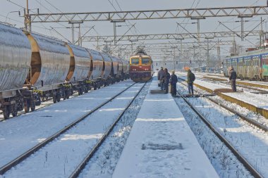 DUGO SELO, CROATIA - 25 Ocak 2023: Aydınlık bir kış gününde Dugo Selo tren istasyonunda karla kaplı bir trenin yakınları.