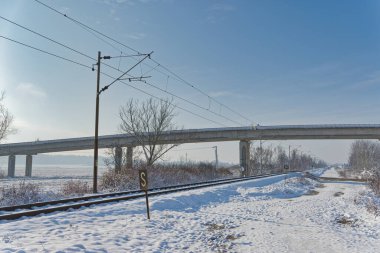 Dugo Selo 'nun huzurlu kırsal kesimindeki bir köprünün altından geçen karla kaplı tren raylarıyla sakin bir kış günü..