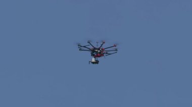 Açık mavi gökyüzünde uçan uzaktan kumandalı bir insansız hava aracı insansız hava araçlarında modern teknolojiyi temsil ediyor..