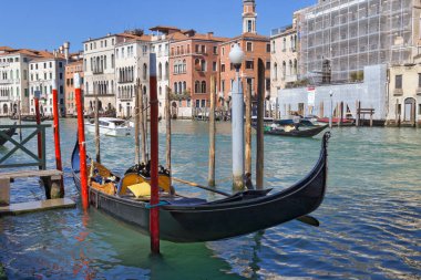 Venedik, İtalya - 10 Nisan 2023 Gondol, Büyük Kanal 'daki bir tahta direğe bağlı bir halatla bekliyor..