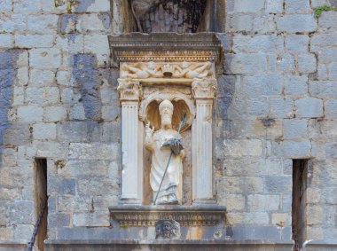 Stone statue of Saint Blaise above west entrance gate at protective city walls of Dubrovnik. clipart