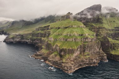 Faroe adaları bulutlu gün dramatik kıyı şeridi ve uçurumlar. Helikopter