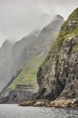 Faroe adalarındaki yeşil kayalıklar ve Atlantik Okyanusu. 