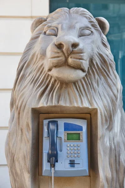 ライオンの頭の彫刻の中の絵のような通りの電話キャビネット — ストック写真