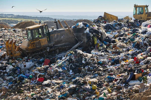 stock image Heavy machinery shredding garbage in an open air landfill. Waste