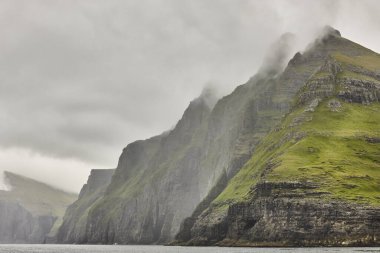 Faroe adalarındaki yeşil kayalıklar ve Atlantik Okyanusu. 