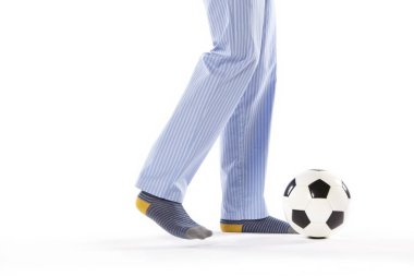 Pijamalı genç adam futbol oynuyor. Bacak detayı. Gece elbisesi