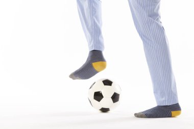 Pijamalı genç adam futbol oynuyor. Bacak detayı. Gece elbisesi