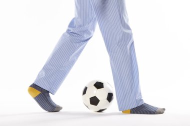 Pijamalı genç adam futbol oynuyor. Bacak detayı. Gece elbisesi