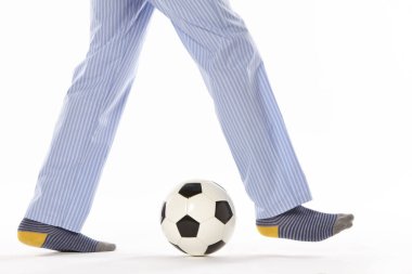 Pijamalı genç adam futbol oynuyor. Bacak detayı. Gece elbisesi