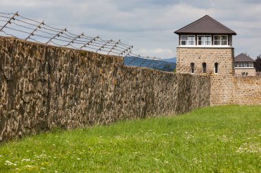 Mauthausen toplama kampı. Çitleri ve gözetleme kulesi olan bir duvar. Avusturya