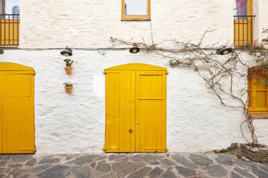 Resimli sarı kapılar beyaz bir cephede. Kadavralar, Girona. İspanya