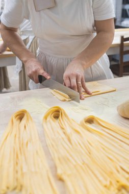 Geleneksel İtalyan aşçı makarna kesiyor. Lezzetli ev yapımı yemekler. İtalya