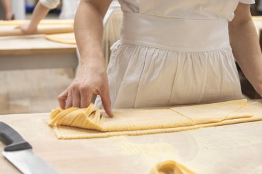 Geleneksel İtalyan aşçı makarna kesiyor. Lezzetli ev yapımı yemekler. İtalya