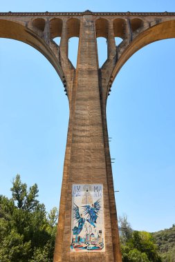 Concrete train bridge with picturesque mosaic in Guadalupe, Caceres, Spain clipart