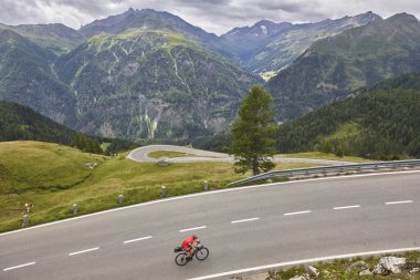 Alp Serpentine dağ yolunda bisikletçi. Avusturya 'nın tarihi rotası