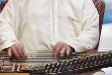 Traditional moroccan musician with wooden string instrument. Qanun clipart