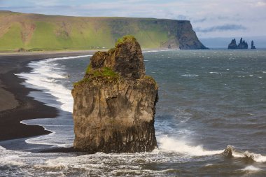 Kayalık sahil şeridi ve bazaltik yığınlar. Vik. Dyrholaey bölgesi. İzlanda