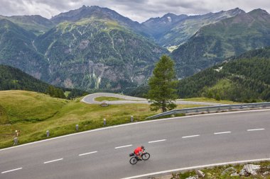 Alp Serpentine dağ yolunda bisikletçi. Avusturya 'nın tarihi rotası