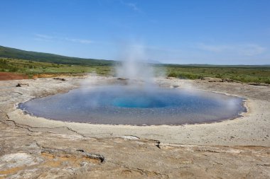 Strokkur gayzerleri kaynar su püskürtüyor. İzlanda tarihi doğa cazibesi