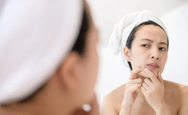 걱정하는 아시아인 여자들은 욕실에 근처에서 여드름을 튀겼다 얼굴을 조사하는 고통받는 — 스톡 사진