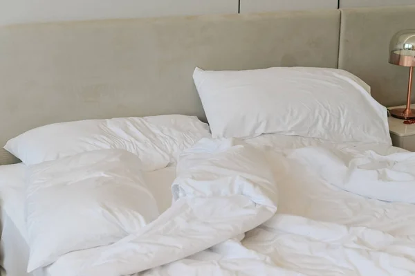 Unmade messy bed after comfortable sleep concept. unmade bedding sheets and pillow
