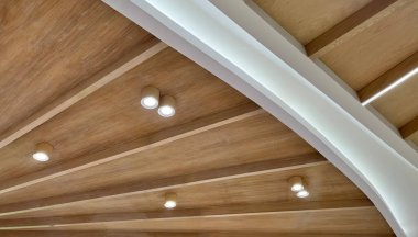 The texture of wooden boards. Ceiling made of wooden planks with LED strip lamps. Idea for a wooden plank ceiling design for a loft style interior.