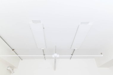 Electrical wires and pipes on house concrete ceiling background, plastic hoses with cables in empty room. Lines of pvc tubes, conduit after professional work. Renovation of home or factory interior.