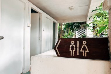 Umumi tuvaletler sarı arka plandaki erkekler ve kadınlar için şarkı söyler, bir kütüğe iliştirilmiş. Tuvaletler doğada, parklarda, dışarıda, kamp yerlerinde..