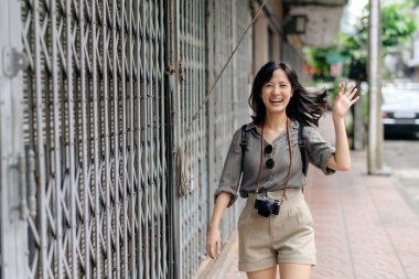 Young Asian woman backpack traveler enjoying street cultural local place and smile. Traveler checking out side streets.