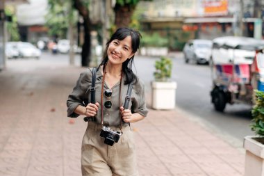 Young Asian woman backpack traveler enjoying street cultural local place and smile.