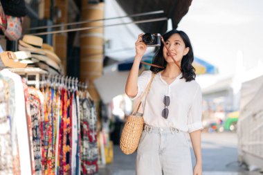 Portrait of young beautiful woman with camera explore street in Bangkok, Thailand